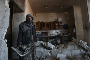 Umm Ali stands in her kitchen, which was destroyed by the 6 February 2023 earthquakes [Photo by Asaad Al Assad]