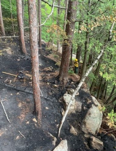 Forest Ranger on steep incline helping extinguish wildfire