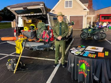 Rangers stands with rescue equipment around him during outreach event at firehouse