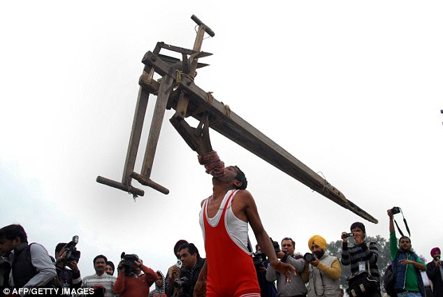 Amazing test of dental strength: A man lifts a plough with his mouth at the Rural Olympics in India 