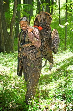 Successful turkey hunter standing in a field