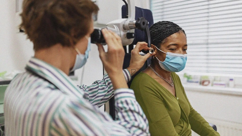 a doctor examining a person's ear