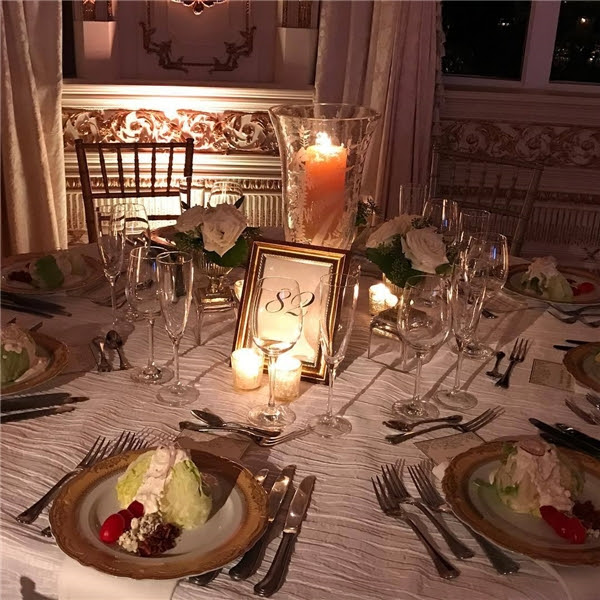 Trên bàn thì có hoa hồng và những chiếc đĩa vàng dùng cho món khai vị.