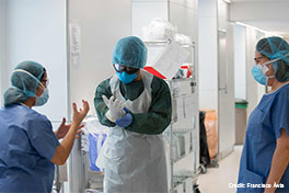 Healthcare workers in Spain put on personal protective equipment, or PPE.