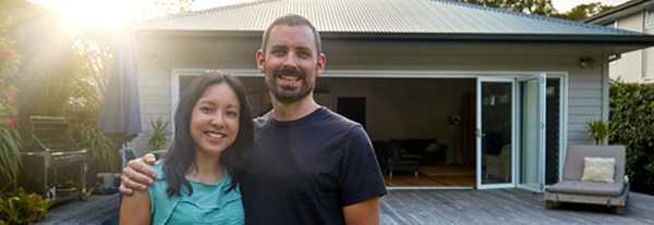 couple standing outside their recently built home