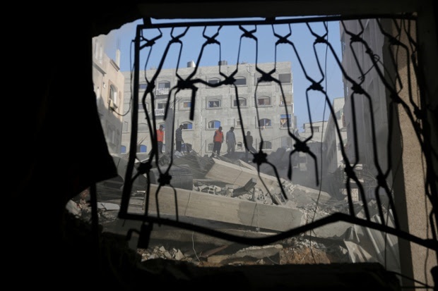 Palestinians inspect the rubble of a house after it was hit by an Israeli missile strike in Gaza City.