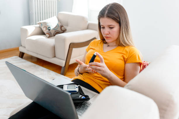 young woman checking blood sugar level at home young woman checking blood sugar level at home control blood sugar levels stock pictures, royalty-free photos & images