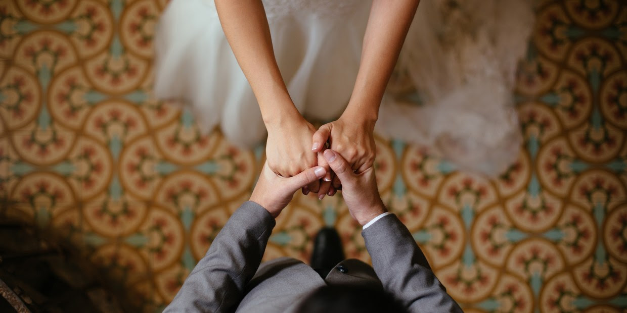Overhead view of bride and groom holding hands Overhead view of bride and groom holding hands