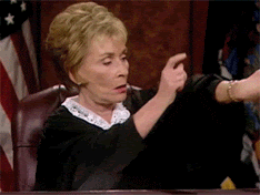 Judge Judy tapping her watch as if to tell someone “Hurry up!”