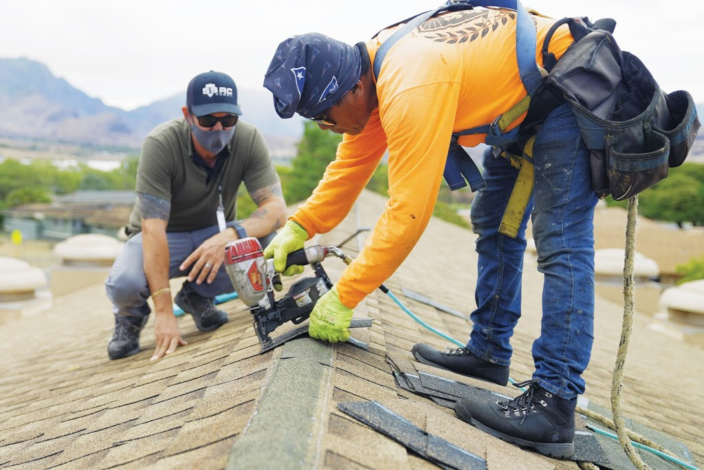 Shon Gregory, left, with a member of his team. | Photo: Courtesy of Surface Shield Roofing