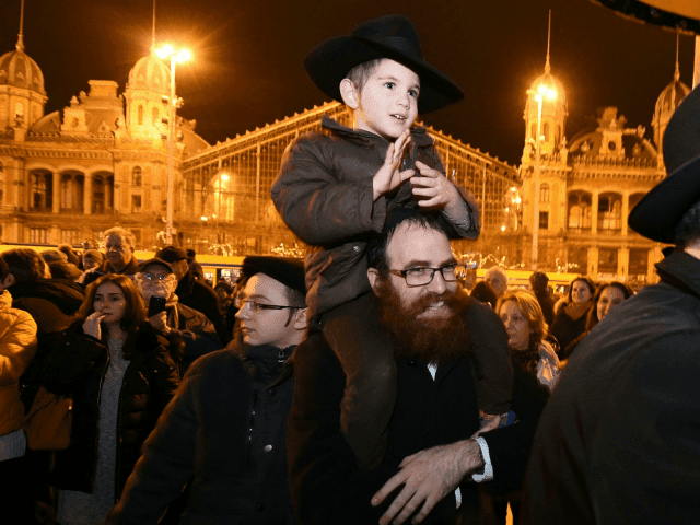 Hungarians from the Jewish community take part in a ceremony during which a giant Menorah is lit to mark the start of Hanukkah celebrations on December 12, 2017 at the Western square in the center of Budapest Hanukkah commemorates the re-dedication of the holy temple in Jerusalem after the Jews' â?¦