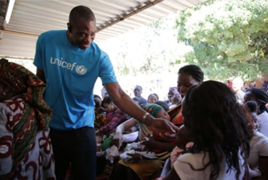 Dikembe Mutumbo greets mothers and babies at a severe acute malnutrition center in Maputo, Mozambique