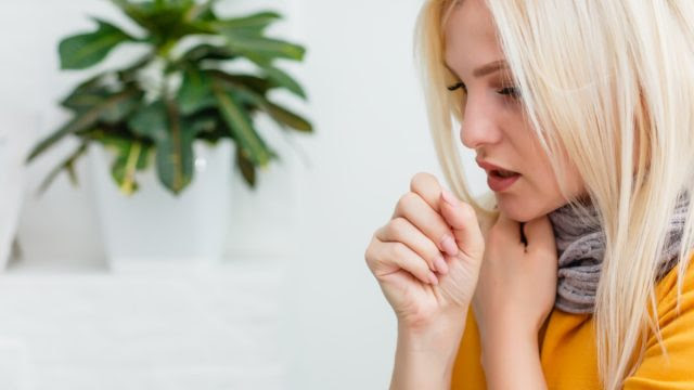 Blonde woman coughing.