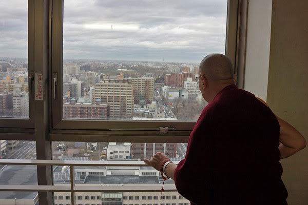 Đức Đạt Lai Lạt Ma tại khách sạn đứng ngắm nhìn Thành phố Sapporo, Nhật Bản. 03/04/2015. (Ảnh: Jeremy Russell)