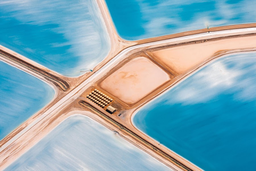An aerial view of blue fields among a network of roads and dikes.