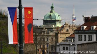Chinese flag sprayed with black substance next to Czech flag