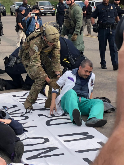 Protesting doctor is arrested by armed officer in full paramilitary gear