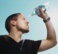 Man sweating and pouring water on self