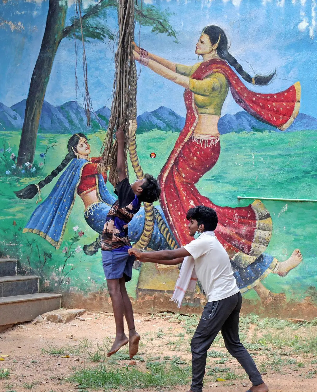लॉकडाउन के दौरान बेंगलुरु में एक दीवार पर चित्रित म्यूरल के सामने खेलते हुए बच्चे.