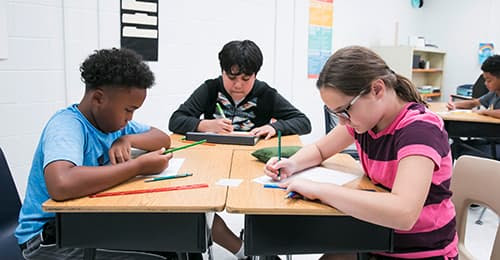 A group of students working at desks.