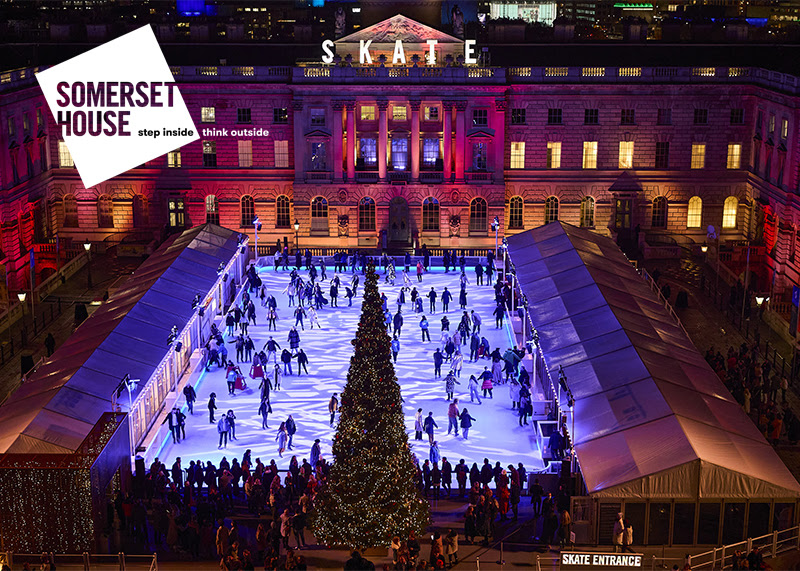 Skate at Somerset House. A photo of the courtyard from above. The ice rink is lit blue and the building is lit in pinks and purples in a festive wintery scene.