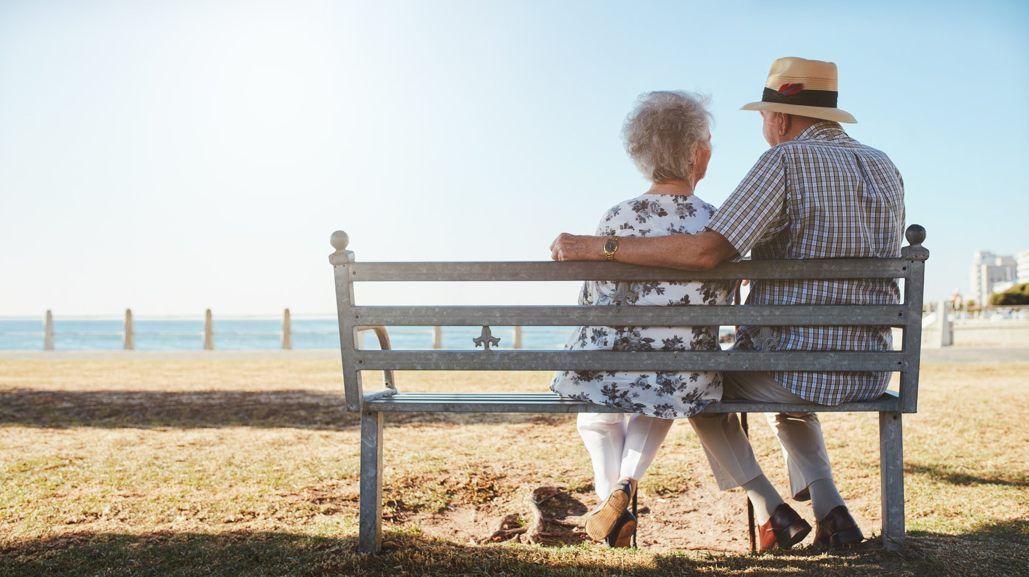 An older couple sits on the beach.