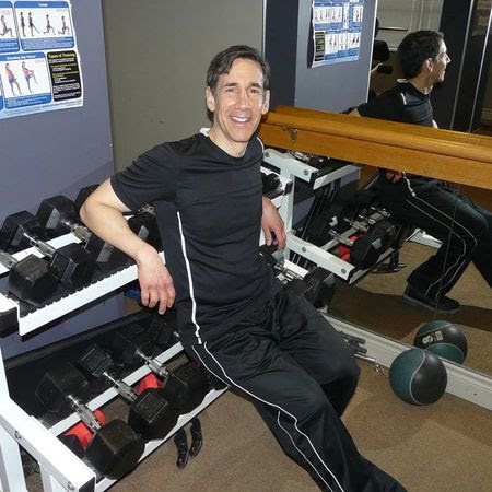 Man sitting on rack of weights
