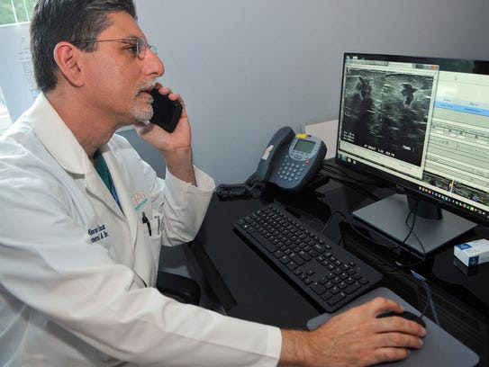 Dr. Emran Imami reviews a patient’s scans before performing