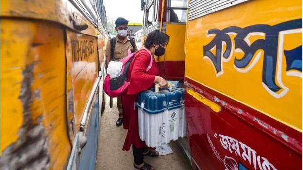 Big responsibility: Polling officials carrying EVMs getting ready to travel to polling centres from a distribution centre, on the eve of the fourth phase of the West Bengal Assembly polls, in Kolkata. 