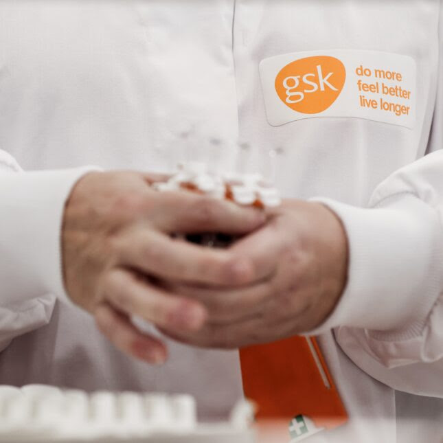 wearing a GSK tag, an employee holds several tubes in their hands – coverage from STAT