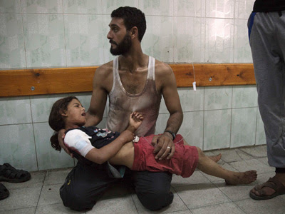 Un hombre espera atención médica para su hija, herida en el bombardeo de la escuela de la ONU. REUTERS/Finbarr O'Reilly