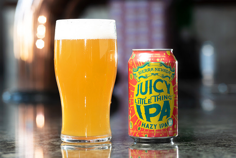 A full glass and single can of Juicy Little Thing