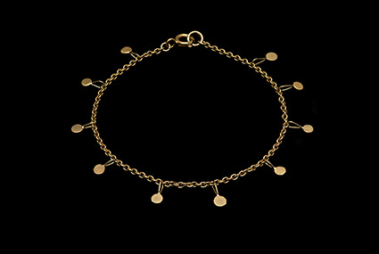  A photograph of a golden necklace by Gillian Finlay, displayed on a solid black background.