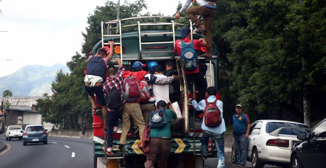 Migrantes hondureños que tratan de alcanzar EEUU, subidos a un autobús a su paso por la capital de Guatemala. REUTERS/Edgard Garrido