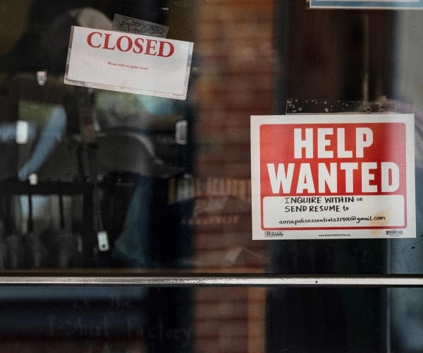 Help-wanted signs on a glass door