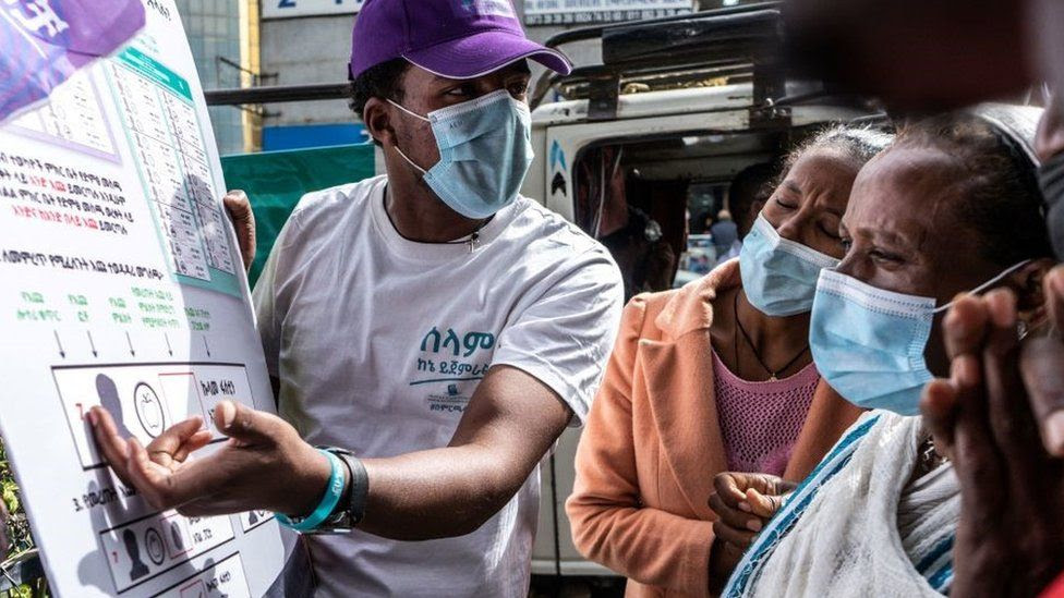 This picture taken in Addis Ababa on June 17, 2021 shows staff members of the National Electoral Board explaining to people how to vote for the upcoming June 21, 2021 elections