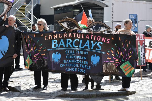 People hold a banner that says Congratulations Barclays, still the number 1 european bankroller of fossil fuels since 2016