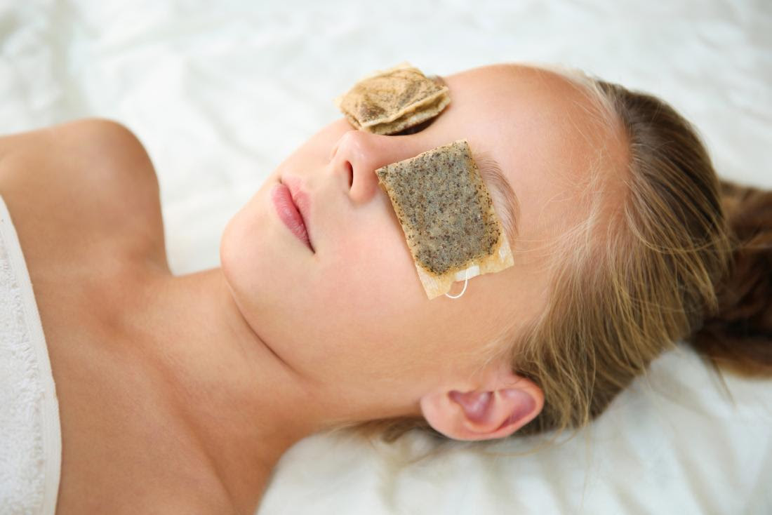 a woman with Tea bags on her eyes for health benefits.
