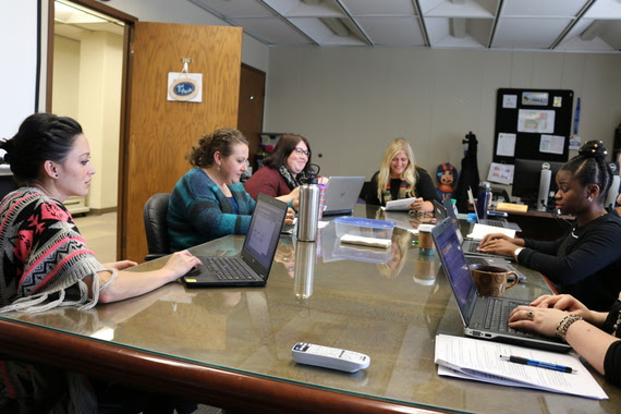 WDE staff sit and talk with AIR staff at a conference table in the WDE.