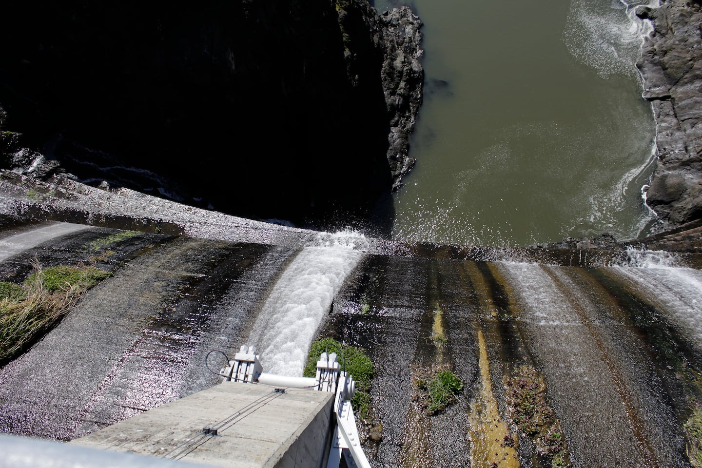 Excess water spills over the top of a dam on the Lower Klamath River known as Copco 1 near Hornbrook, Calif. in 2020. A plan to demolish four dams on California's second-largest river to benefit threatened salmon has sharpened a decades-old dispute over who has the biggest claim to the river's waters. The project, if it goes forward, would be the largest dam demolition project in US history and would include the Copco 1 facility pictured.