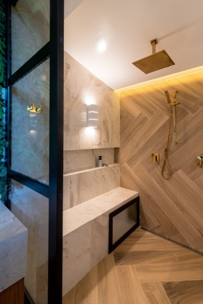 Na sala de banho, a arquiteta Mari Milani investiu no requinte do dourado para o chuveiro e os metais que o acompanham | FOTO: Erika Urbino