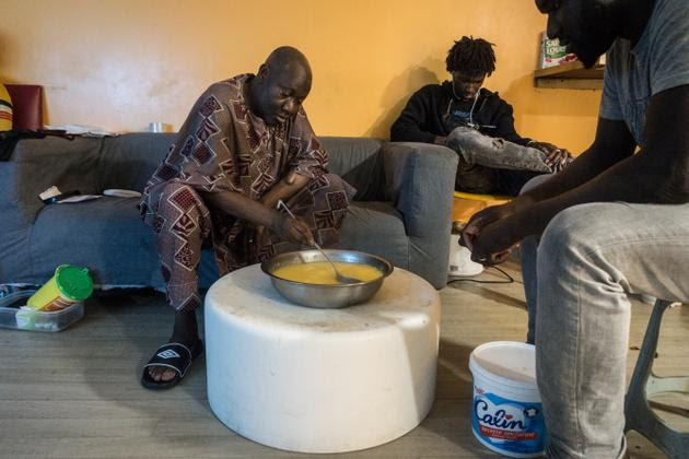 M. Baradji prépare le sombi pour Diaguely, qui s'apprête à partir au travail. M. Baradji vit en France depuis 50 ans. C'est le plus ancien de l'étage du foyer, il organise la vie des plus jeunes arrivés recemment en France.