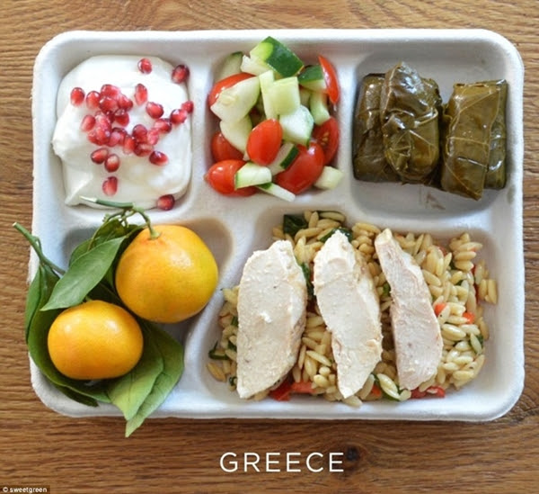 Ăn trưa trường học Hy Lạp đặc trưng có món gà nướng, lá nho nhồi bông, salad dưa chuột cà chua, sữa chua hạt lựu và hai quả cam.