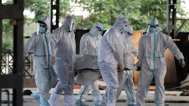  Health workers and family members, wearing protective suits, carry the body of a person who died of COVID-19, at Cremation Ground in Jammu, Monday, April 19, 2021. 