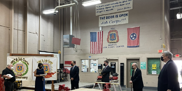 Secretary Walsh and others stand in a Tennessee Job Corps Center. A sign on the wall reads: I don’t want nobody to give me nothing. Open up the door and I’ll get it myself. James Brown. Another reads: The Door Is Open: Job Corps!