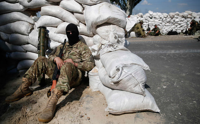 Un miliciano prorruso espera en un puesto de control cercano a Donetsk.