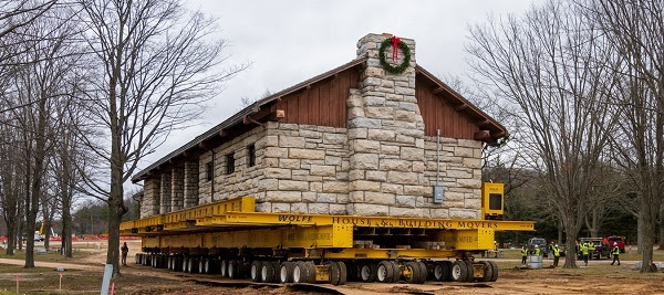 The historic shelter building at Orchard Beach State Park sits atop of a flatbed as it moves to new site further inland.