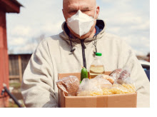 Elderly veteran holding a box of food.