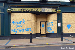 Boarded up restaurant with messages of support to healthcare workers.