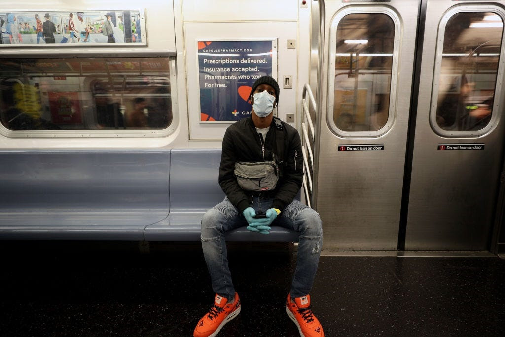 A man wears a face mask and surgical gloves to prevent Covid-19 spread, at the New York City subway train in New York, United States on March 11, 2020.